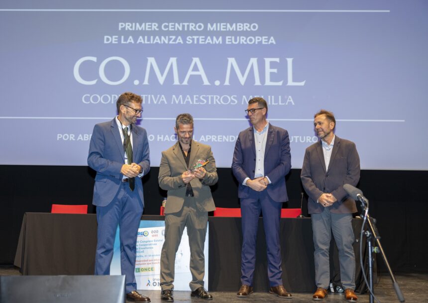 Cuatro hombres en un escenario junto a una pantalla con el logotipo de COMAMEL
