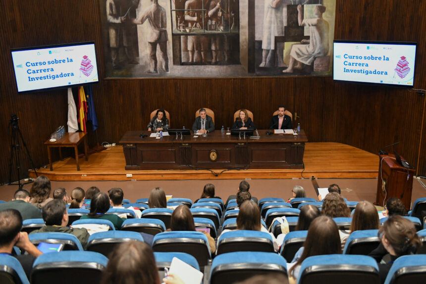 Auditorio con mesa y pantallas con el rótulo «Curso sobre la Carrera Investigadora»