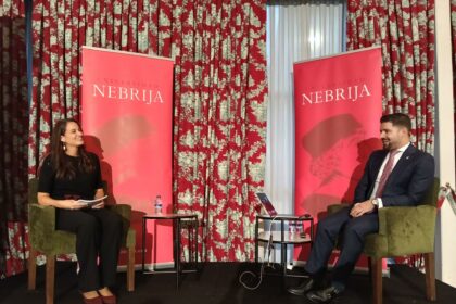 Dos personas sentadas ante paneles de la Universidad Nebrija
