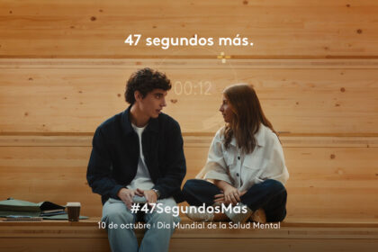 Dos jóvenes conversan sentados en un banco de madera en un fotograma de la campaña 47 segundos más