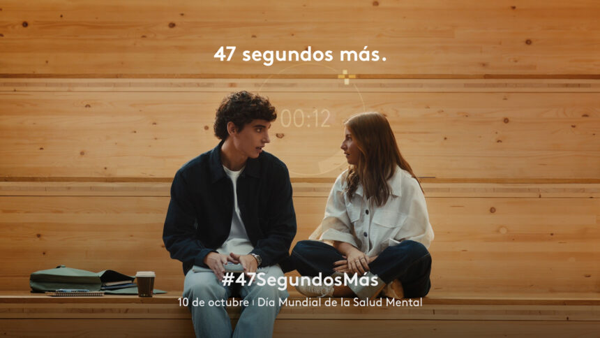 Dos jóvenes conversan sentados en un banco de madera en un fotograma de la campaña 47 segundos más